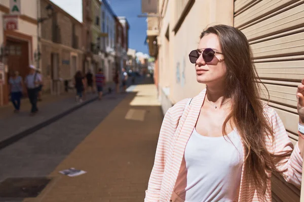 Porträtt av en ung flicka klädd i vita kläder gå på gatan — Stockfoto