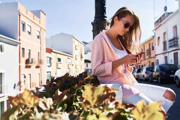 Hermosa chica caminando y escribiendo mensajes en un teléfono móvil en —  Fotos de Stock