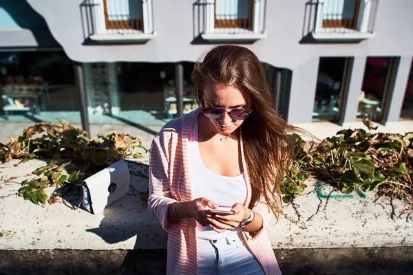 Πορτρέτο ενός κοριτσιού που περπατάει και γράφοντας μηνύματα σε ένα κινητό τηλέφωνο στο δρόμο — Φωτογραφία Αρχείου