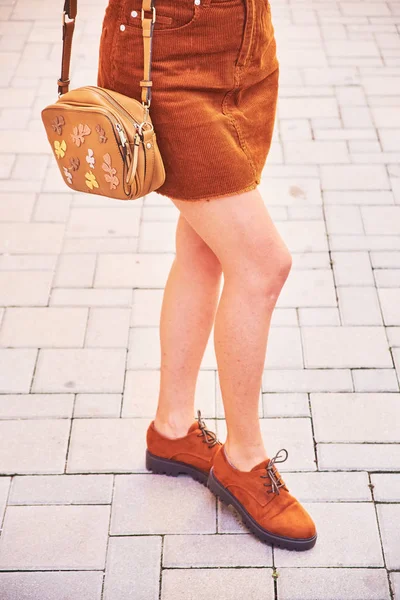 Κοντινό-up των γυμνά γυναικεία πόδια σε σύντομο πολύχρωμο βελούδο φούστα και σουέτ παπούτσια — Φωτογραφία Αρχείου