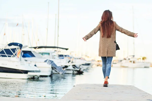 Girl in a stylish coat poses in the port — Stock Photo, Image