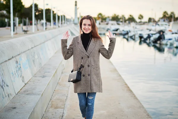 Chica divertida en un abrigo elegante posa en el puerto —  Fotos de Stock