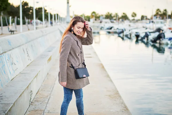 Девушка в стильном пальто прогулка в порту — стоковое фото