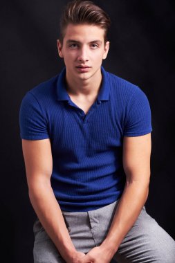 Zarif genç yakışıklı adam siyah arka plan üzerinde poz