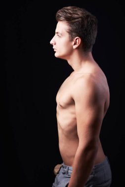 Gömleksiz genç adam profil görünümü siyah izole