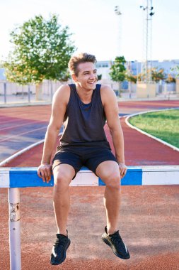 Young muscular man posing on stadium