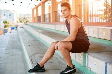 Young muscular man posing on stadium