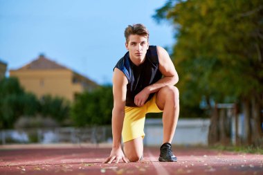 Stadyumda poz veren genç kaslı adam.