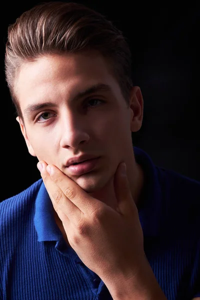 Elegant young handsome man posing on black background