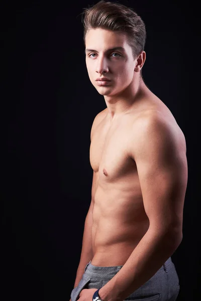 Studio portrait of handsome muscular shirtless young man isolated on black — Stock Photo, Image