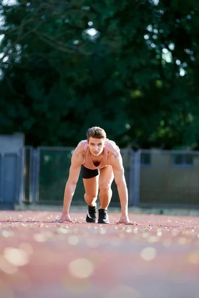 Jeune homme en forme et confiant en position de départ prêt à courir — Photo