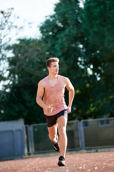 Young muscular man running on the track