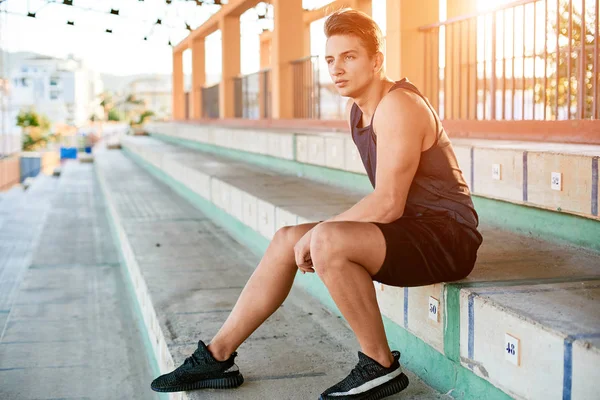 Young muscular man posing on stadium — Stockfoto