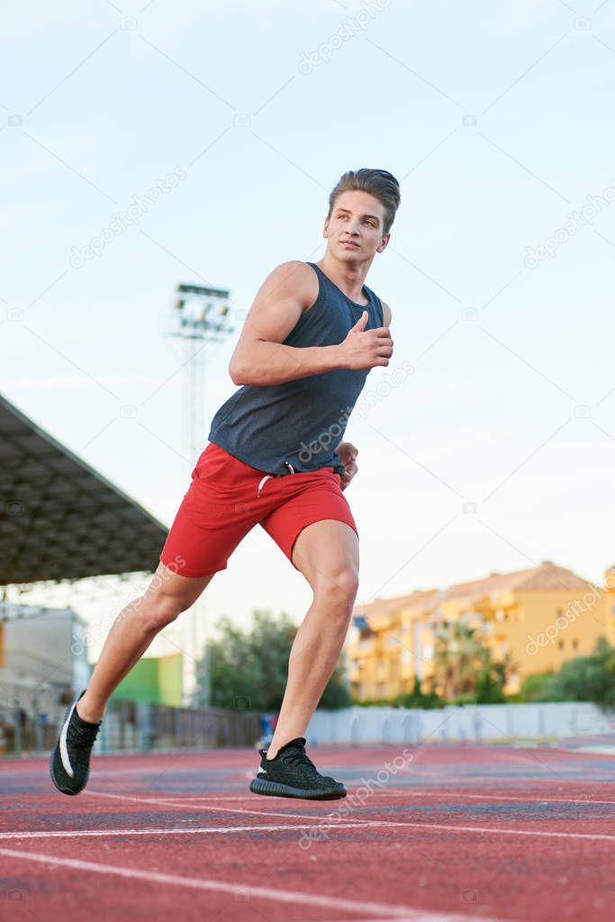 Young muscular man running on the track