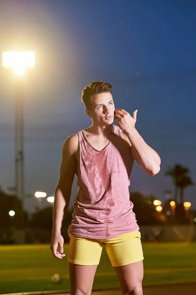 Portrait d'un jeune sportif transpirant musclé posant sur le stade — Photo