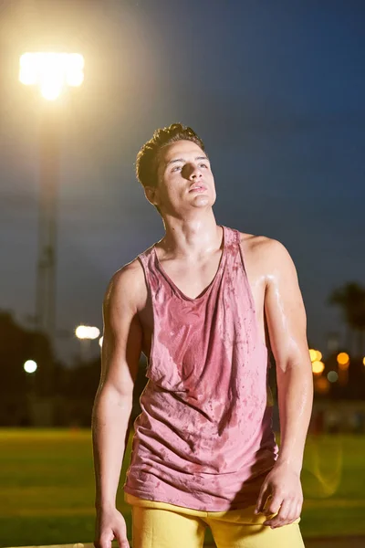 Portrait d'un jeune sportif transpirant musclé posant sur le stade — Photo