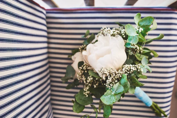 Bruiloft boeket met rozen ligt op een gestreepte houten stoel — Stockfoto