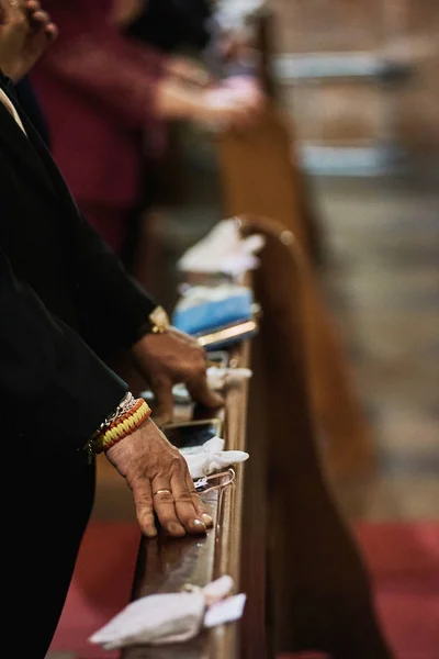 Mãos de um homem sênior com anel no dedo permanecendo em uma igreja . — Fotografia de Stock