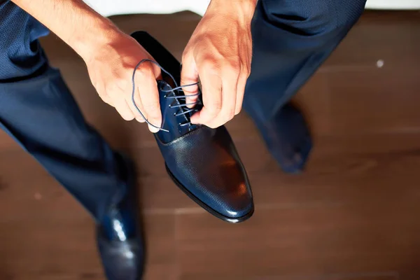 Un hombre elegante se pone zapatos negros, de cuero, formales. Atando zapatos . — Foto de Stock