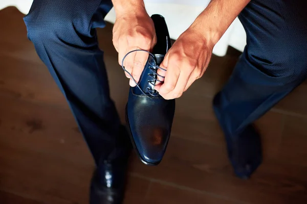 Ein eleganter Mann zieht schwarze, lederne, formelle Schuhe an. Schuhe binden. — Stockfoto