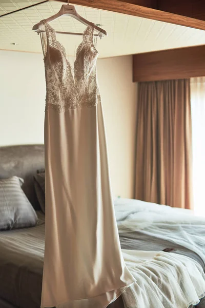 Robe de mariée suspendue au plafond dans une chambre d'hôtel de luxe — Photo