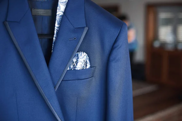 Primer plano del nuevo traje azul del novio y corbata colgando de una percha — Foto de Stock