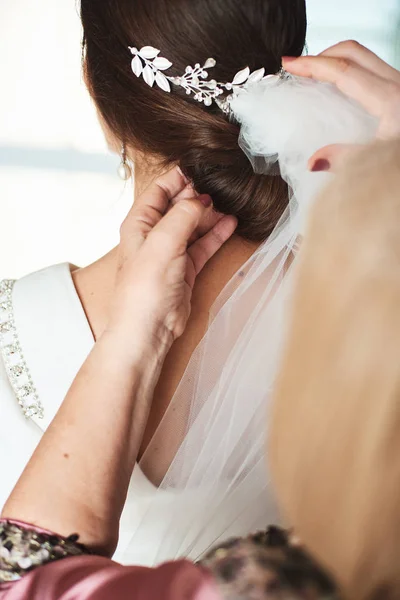 Mother preparing her daughter for a wedding day