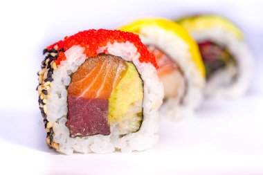 Somon, avokado, ton balığı ve salatalık izolat ile üç suşi rulo