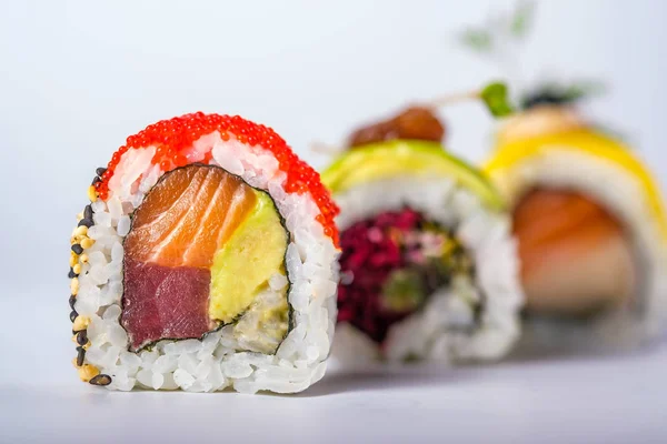 Three sushi rolls with salmon, avocado, tuna and cucumber isolat — Stock Photo, Image