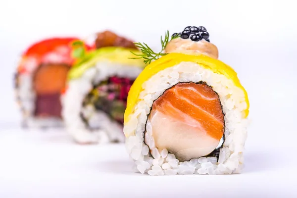 Tres rollos de sushi con aislante de salmón, aguacate, atún y pepino — Foto de Stock