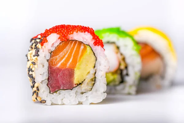 Tres rollos de sushi con aislante de salmón, aguacate, atún y pepino — Foto de Stock