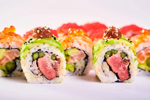 Primer plano de los rollos de sushi uramaki con caviar rojo, salmón y aguacate — Foto de Stock