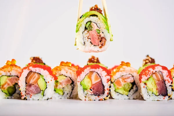 Blízko rohlíků uramaki sushi a samičí držka s hůlky — Stock fotografie