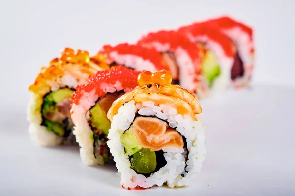 Primer plano de los rollos de sushi uramaki con caviar rojo, salmón y avoc — Foto de Stock