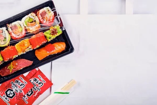 Vista superior de nigiri sushi e rolos de uramaki definidos em plástico takeaw — Fotografia de Stock