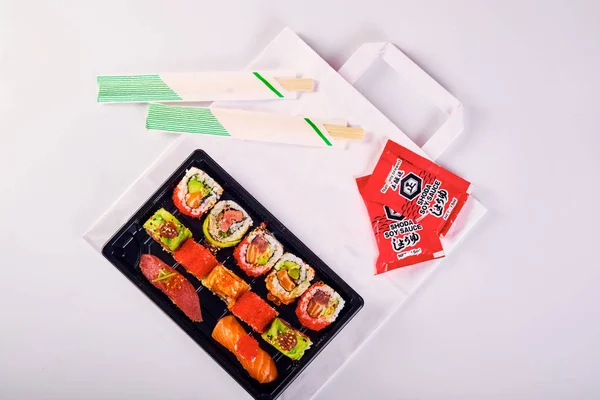 Vista superior de nigiri sushi e rolos de uramaki definidos em plástico takeaw — Fotografia de Stock