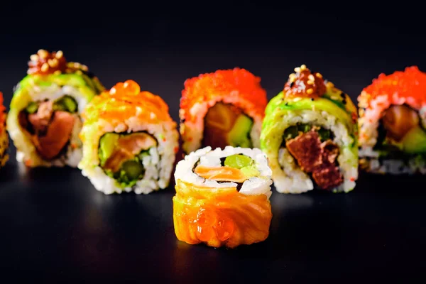Close-up of uramaki sushi rolls with red caviar, salmon and avocado — Stock Photo, Image