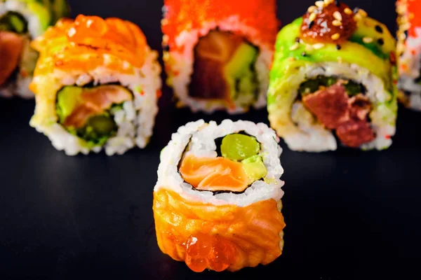 Primer plano de los rollos de sushi uramaki con caviar rojo, salmón y aguacate — Foto de Stock