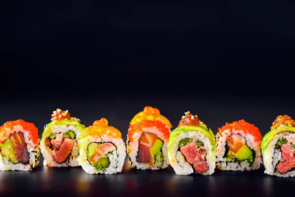 Primer plano de los rollos de sushi uramaki con caviar rojo, salmón y aguacate — Foto de Stock