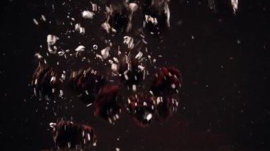 Böğürtlensiyah arka plan karşı suya düşen yavaş hareket. Taze meyveler bir kapta batıyor. Kopyalama alanı.