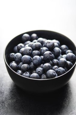 Koyu arka planda siyah kase taze aldı yaban mersini.