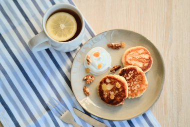 Ekşi Krem ve çay fincan ile ev yapımı peynir krep syrniki üst görünümü