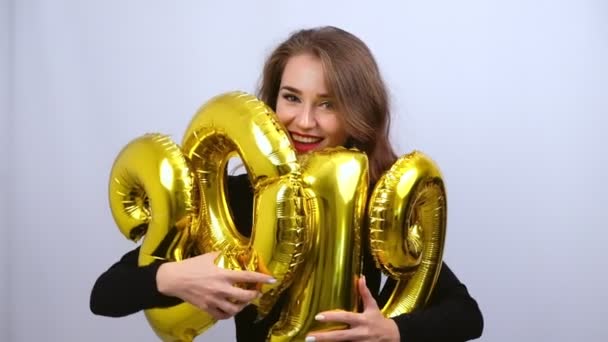 黄金の2019風船を持ち 笑顔を持つ幸せな女の子 スローモーション 新年とクリスマスのコンセプト — ストック動画