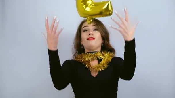 白い背景にナンバー2で金色の風船をキャッチ美しい幸せな女の子 スローモーション 新年とクリスマスのコンセプト — ストック動画