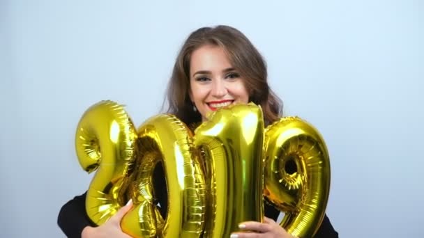 快乐的女孩拿着金色的2019气球和微笑 慢动作 新年和圣诞节概念 — 图库视频影像