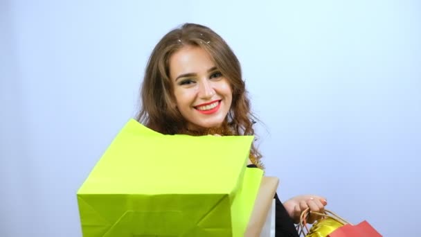 Jovem Mulher Vestido Preto Segurando Sacos Compras Coloridos Sorrindo Isolado — Vídeo de Stock