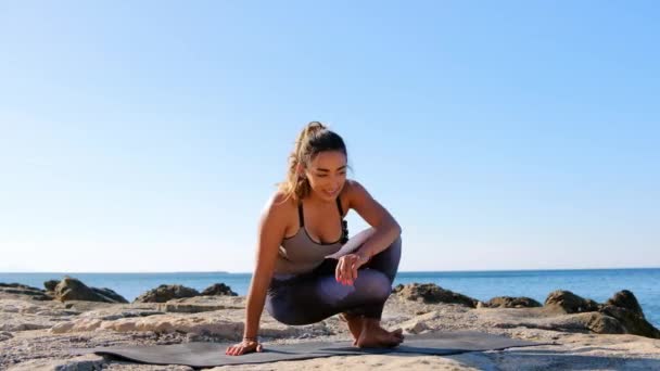 Jovem mulher hispânica atraente pratica ioga na praia . — Vídeo de Stock