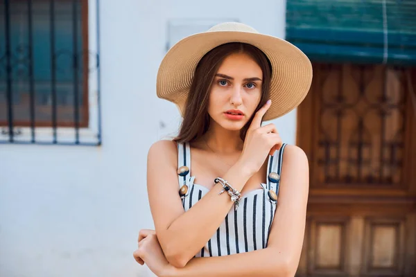 Retrato de moda de mujer joven elegante en sombrero de paja caminando por la calle . — Foto de Stock