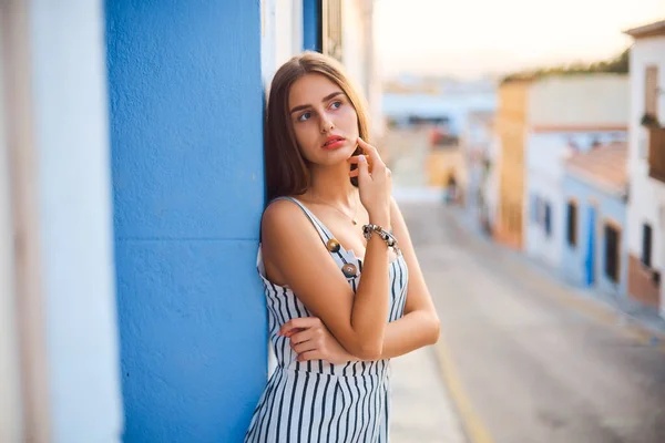 Retrato de moda de jovem mulher elegante posando contra a parede azul . — Fotografia de Stock