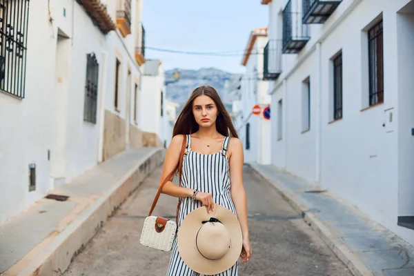 Joven mujer elegante con sombrero de paja caminando por las estrechas calles del casco antiguo . —  Fotos de Stock